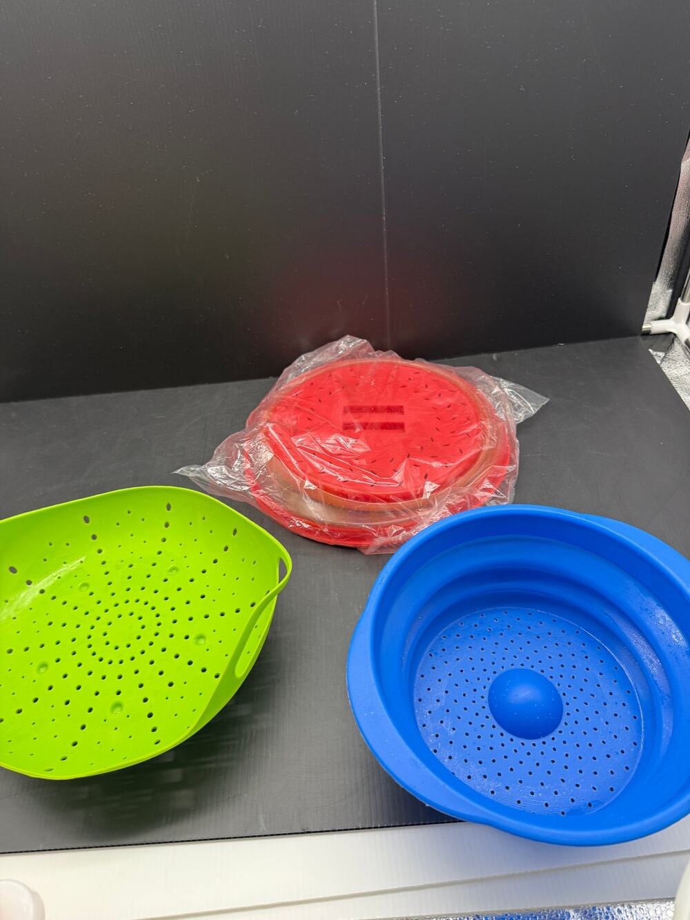 Collapsible silicone colanders & steamers in vibrant green, blue, & red colors.
